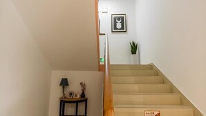 A staircase with a handrail and a small table with a lamp and decorative items. - Shell Shanghai Yangpu District North Bund Pingliang Road Riverside Hotel (Shanghai)