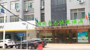 A hotel with a modern facade, multiple air conditioning units, and a sign with green text. - Greentree Inn Yangzhou Dongguan Street Geyuan Garden Express Hotel (Yangzhou)