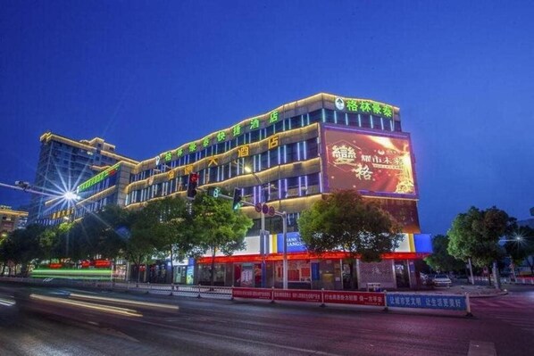 A multi-story hotel with a prominent sign on the facade, multiple floors, and a well-lit exterior.