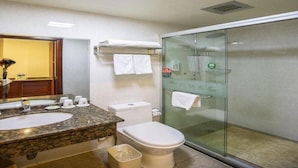 A bathroom with a granite countertop sink, a toilet, and a glass-enclosed shower. - Greentree Inn Xinghua Middle Yingwu Road Express Hotel (Taizhou)