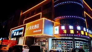 A hotel with a prominent sign in Chinese characters, multiple floors, and illuminated exterior lighting. - Shell Tai'an Taishan District Xinhuacheng International Plaza Hotel (Tai'an)