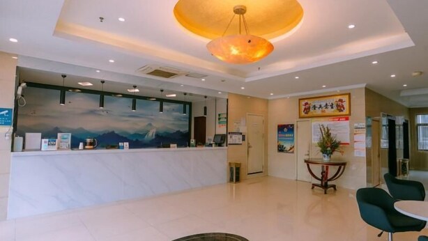 A hotel reception area with a marble counter, a large mural, and a modern chandelier. - Greentree Inn Maanshan West Jiuhua Road Wanda Plaza Mengniu Diary Express Hotel (Ma'anshan)