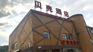 Ein Gebäude mit einer auffälligen Beschilderung oben, einem großen Glas Eingang und einer Holzfassade.