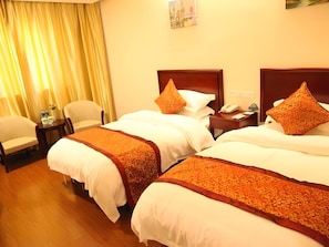 Quarto de hotel com duas camas, uma cadeira, mesa de cabeceira e um quadro na parede.