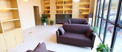 Una sala de estar moderna con un conjunto de sofá, televisión y estantería.