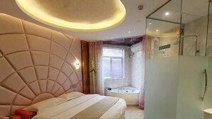 A modern bedroom with a large bed, a glass-enclosed shower, and a small red side table. - Greentree Alliance Shanghai Hongqiao Airport Zoo Metro Station Hotel (Shanghai)