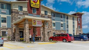 A My Place hotel with a 'Now Open' sign, featuring a stone facade and multiple windows. - My Place Hotel, Mount Pleasant WI (Mount Pleasant)