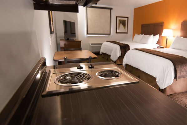 A hotel room with a kitchenette, a bed, a bedside table, and a chair. - My Place Hotel-pittsburgh North/monaca, PA (Monaca)