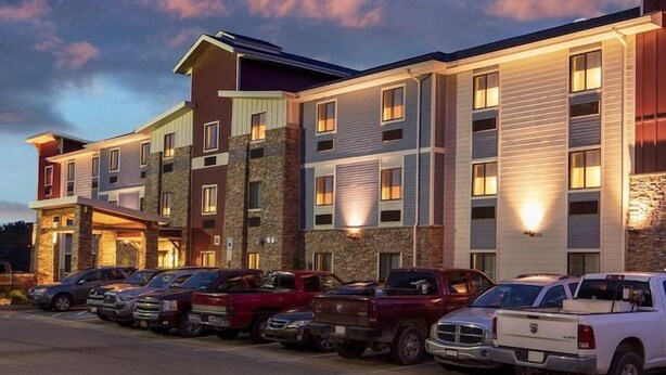 A multi-story hotel with a stone facade, multiple parking spaces, and a 'MY PLACE' sign. - My Place Hotel-pittsburgh North/monaca, PA (Monaca)