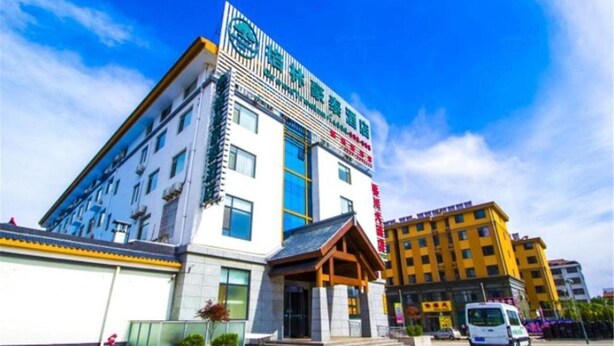 A multi-story hotel with a prominent sign, a covered entrance, and a parking area. - Greentree Inn Shandong Weifang Linqu Zhanqian Road Luchuan Business Hotel (Weifang)