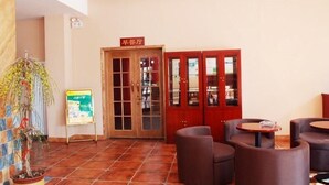 A lobby with a tiled floor, wooden doors, and a sign indicating a restaurant. There are seating areas with chairs and tables. - Greentree Inn Shandong Weifang Linqu Zhanqian Road Luchuan Business Hotel (Weifang)
