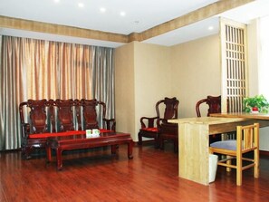 A room with a wooden dining table, four wooden chairs, a sofa, and a curtain. - Greentree Inn Shandong Weifang Linqu Zhanqian Road Luchuan Business Hotel (Weifang)