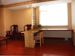 A room with a wooden dining table, two chairs, a bench, a window with blinds, and a plant on the windowsill. - Greentree Inn Shandong Weifang Linqu Zhanqian Road Luchuan Business Hotel (Weifang)