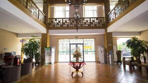 A spacious lobby with a high ceiling, wooden beams, and a central decorative plant. - Greentree Inn Shandong Weifang Linqu Zhanqian Road Luchuan Business Hotel (Weifang)