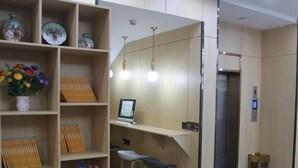 A modern interior with wooden shelving, a desk with a computer, and a small stool. - Greentree Inn Jining Jinxiang Kuixing Road Express Hotel (Jining)