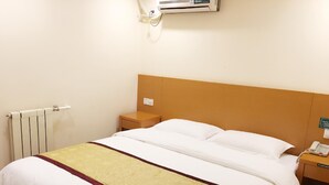 A hotel room with a single bed, a bedside table, a telephone, and a radiator. - Greentree Inn Tianjin Xiqing District Zhongbei Down Xiqing Road Shell Hotel (Tianjin)