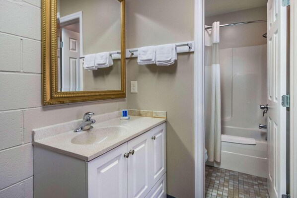 A bathroom with a sink, mirror, towel rack, and shower. - Rodeway Inn and Suites Walhalla SC (Walhalla)