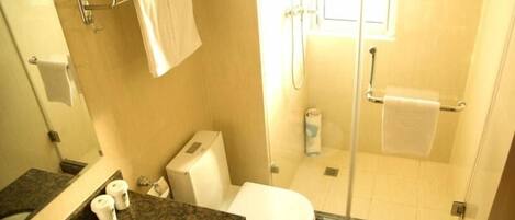 A bathroom with a toilet, sink, and shower area.