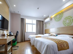 Ein Hotelzimmer mit Bett, Nachttisch, Fernseher und Schreibtisch mit Stuhl.