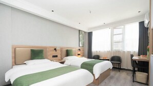 Una habitación de hotel con dos camas, un escritorio y una silla.