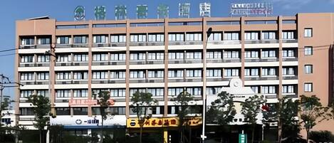 A multi-story hotel with a modern architectural design, featuring a prominent sign at the top.