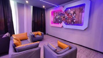 Ein modernes Wohnzimmer mit zwei Sofas und einem Couchtisch, einem großen abstrakten Gemälde an der Wand und einem Fenster mit Vorhängen.
