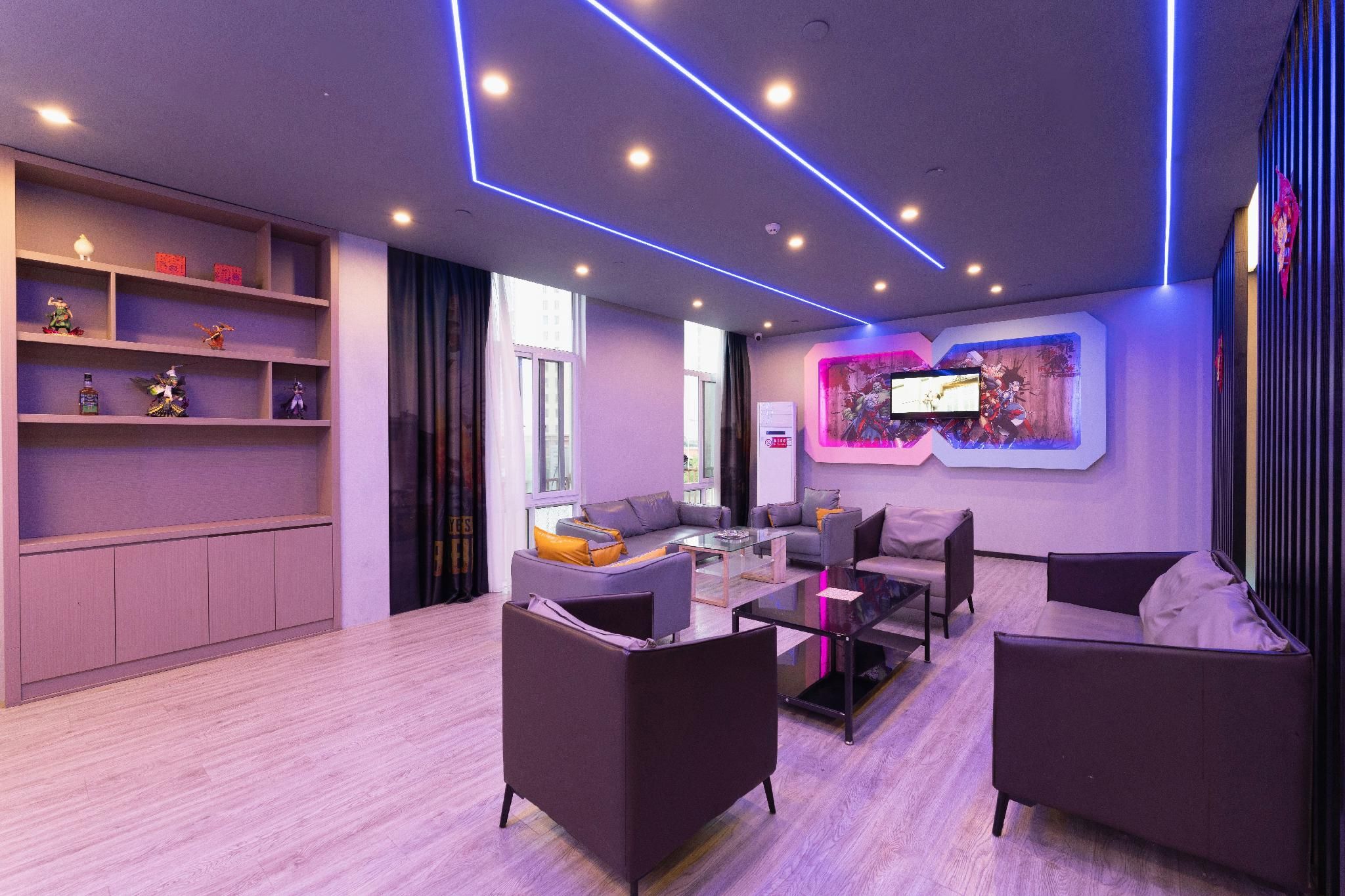 A modern living room with sofas, a coffee table, and a flat-screen TV mounted on the wall.