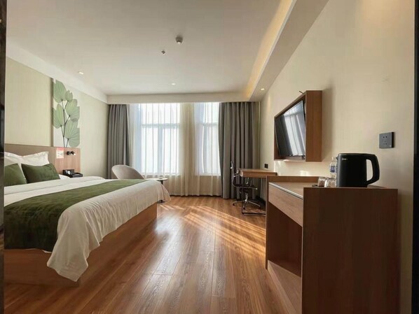 A hotel room with a bed, desk, chair, TV, and coffee maker. - Greentree Inn Anhui Suzhou Yongqiao Qiongyun Market (Suzhou)