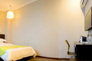 A hotel room with a bed, a desk with a chair, a lamp, and a flat-screen TV. - GT Alliance Urumqi Airport Hotel (Ürümqi)