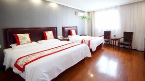 A hotel room with two beds, a wooden floor, a small table, and a chair. - Greentree Inn Wuxi Jiangyin Xinqiao Taoxin Road Express Hotel (Wuxi)
