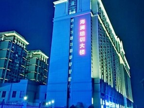 A high-rise building with illuminated signage indicating it is a hotel. - Greentree Inn Wuxi Jiangyin Xinqiao Taoxin Road Express Hotel (Wuxi)