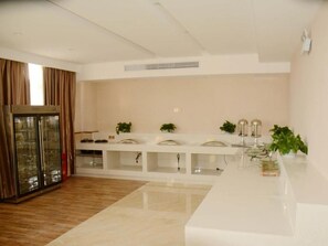 A modern kitchen with a white countertop, glass cabinets, and a built-in oven. - Greentree Inn Lu an Jin an District Bus North Station Express Hotel (Lu'an)