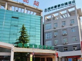 A hotel with a modern facade, multiple floors, and a sign indicating it is a Green Tree Inn Express Hotel.
