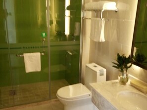 Une salle de bain avec une douche à parois de verre, des toilettes, un lavabo et un miroir.
