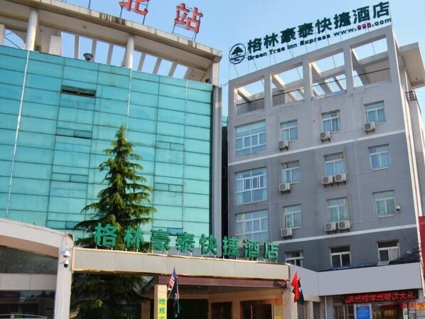 Un hôtel à la façade moderne, avec plusieurs étages, et une enseigne indiquant qu’il s’agit d’un hôtel Green Tree Inn Express.