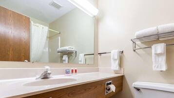A bathroom with a sink, mirror, towel rack, and toilet.