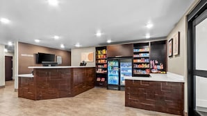 A reception area with a counter, a television, and a refrigerator stocked with beverages.