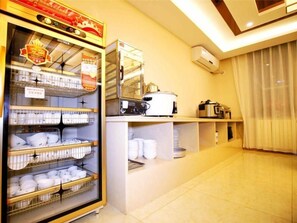 A kitchen area with a glass-fronted refrigerator stocked with white bowls, a stove, and a microwave. - Greentree Inn Beijing Caoqiao Metro Station Xinfadi Business Hotel (Beijing)