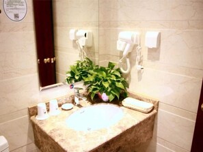 A bathroom with a marble sink, a potted plant, a hairdryer, and a mirror. - Greentree Inn Beijing Caoqiao Metro Station Xinfadi Business Hotel (Beijing)