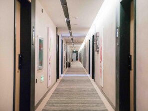 A long, narrow hotel corridor with doors on both sides, a carpeted floor, and a ceiling with recessed lighting. - Greentree Inn Tangshan Nanhu International Exhibition Center (Tangshan)