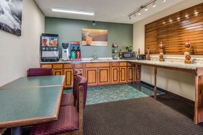 A compact kitchen with a dining table, chairs, and a microwave. - Rodeway Inn & Suites Dublin, GA (East Dublin)