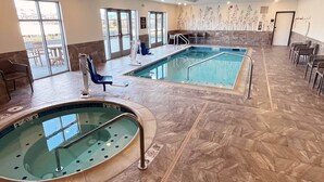 An indoor swimming pool with two separate sections, a seating area with chairs, and a spa tub. - La Quinta Inn & Suites by Wyndham Wenatchee (Wenatchee)