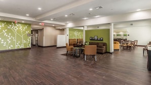 A spacious lobby with a reception area, seating, and a dining area. - Sleep Inn and Suites College Station Area (College Station)