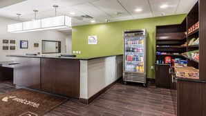 A reception area with a counter, a refrigerator stocked with beverages, and a vending machine. - Sleep Inn and Suites College Station Area (College Station)