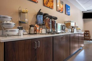 Montaje de bufé con diferentes alimentos y máquinas de café.