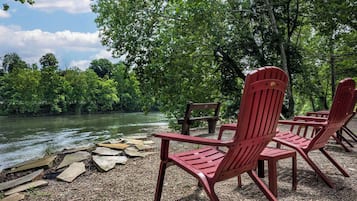 Een zitgedeelte aan de rivier met Adirondack stoelen en een houten terras.
