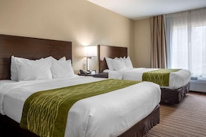 A hotel room with two beds, a nightstand with a lamp, a window with curtains, and a carpeted floor. - Comfort Inn Connellsville Riverview (Connellsville)