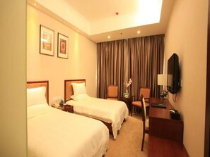 A hotel room with two beds, a desk, a chair, a TV, and a curtain. - Greentree Inn Beijing Chaoyang District Xizhihe Commercial Center Express Hotel (Beijing)