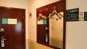A hotel bathroom with a wooden door, a mirror with a towel rack, and a no-smoking sign on the wall. - Greentree Inn Beijing Daxing District Caiyu Fuyuan Road Express Hotel (Daxing)
