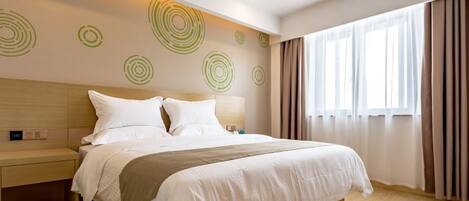 A modern hotel room with a large bed, a wooden headboard, and a wall with circular patterns.